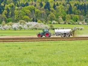 Traktor bringt Gülle auf ein Feld aus