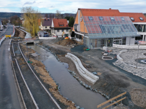Luftaufnahme der Baustelle am Mühlbach (Alte Weismain) während des Baus eines Geh- und Radwegs entlang des neuen Gewässers mit Kneippanlage und Sitzstufen.