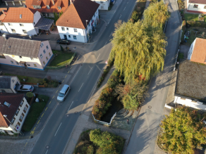 Luftaufnahme des Mühlbachs (Alte Weismain) mit zwei parallel verlaufenden Straßen.