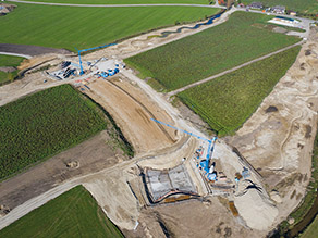 Luftaufnahme während der Baumaßnahme: Zwei neue Drosselbauwerke befinden sich im Bau. Neben den zwei Baugruben jeweils ein Turmdrehkran und Baumaterial.