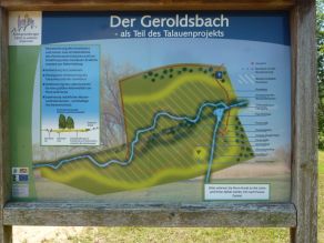 Eine Infotafel zur Renaturierung des Geroldsbachs als Teil des Talauenprojekts. Dargestellt ist ein Lageplan mit Erläuterung der einzelnen Elemente der Gewässererlebnisraums.