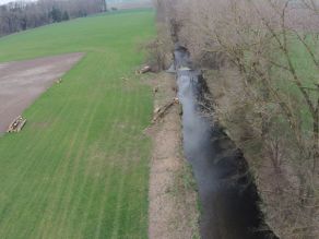 Luftaufnahme der begradigten Mindel flussabwärts mit monotonem Gewässerlauf und angrenzenden landwirtschaftlich genutzten Flächen.