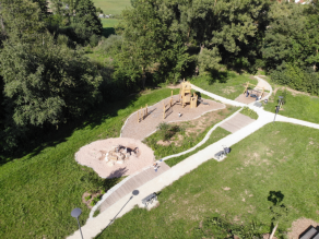 Luftaufnahme des neuen Kinderspielplatzes mit Klettergerüst, Schaukel und Sandspielplatz.